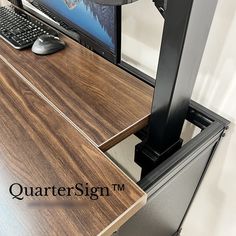 a computer monitor sitting on top of a wooden desk next to a keyboard and mouse