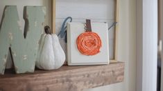 some pumpkins are sitting on top of a mantel with string wrapped around them