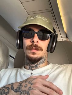 a man wearing headphones and a hat on top of his head in an airplane