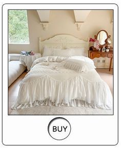 a white bed with ruffled bedspread and pillows