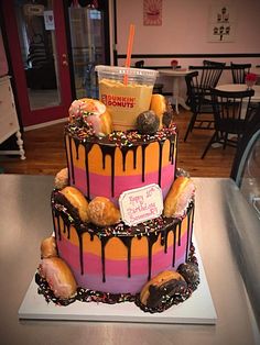 a three tiered cake with donuts and sprinkles