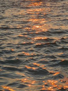 the sun is setting over the water and it looks like they are floating in the ocean