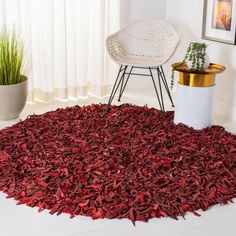 a red rug is in the middle of a room with a chair and potted plant