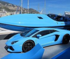 a blue sports car parked next to a speed boat