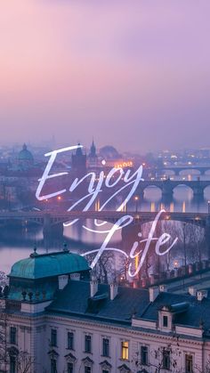 the words enjoy life are lit up in front of an image of a cityscape