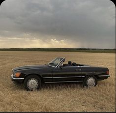 a black convertible car parked in a field