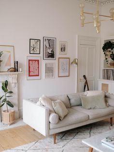 a living room filled with furniture and pictures on the wall