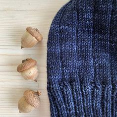 three garlic cloves sitting on top of a blue knitted mitt next to some garlic