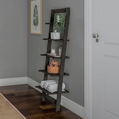 a bathroom with gray walls and white trim on the wall, along with a wooden ladder leaning up against the wall