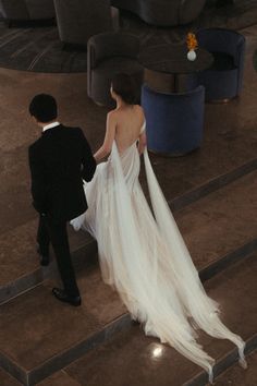 a bride and groom are walking down the stairs