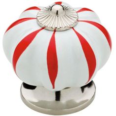 a red and white striped candy box on a silver stand with a metal base for the lid