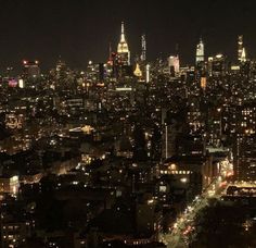 an aerial view of the city at night with lights and skyscrapers in the background