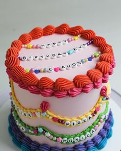 a multi - layered cake decorated with colorful ribbons and beads