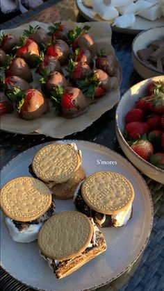 there are many desserts on the table and one has chocolate covered strawberries in it