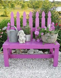 a purple bench with potted plants on it and a teddy bear sitting on the bench