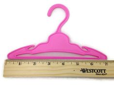 a pink wooden hanger with a measuring ruler in front of it that says westcott