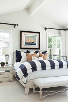 a bedroom with white walls and blue striped bedding