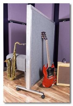 an electric guitar and a saxophone sit in front of a soundboard on the floor