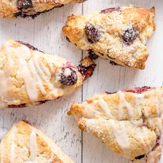 blueberry scones with icing sitting on top of a white table