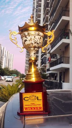 a gold trophy sitting on top of a car