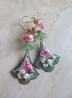 pair of earrings with pink flowers and green leaves