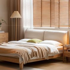 a bed sitting in a bedroom next to a window with blinds on the windowsill