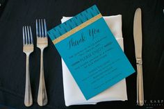 a table set with silverware and a blue thank you card