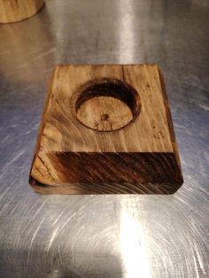 a wooden object sitting on top of a metal table