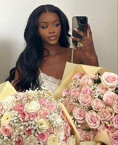 a woman taking a selfie with her phone and bouquets of flowers in front of her