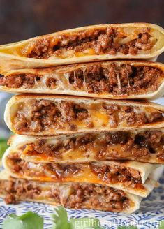 three burritos stacked on top of each other with cheese and meat in them