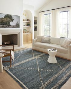 a living room filled with furniture and a fire place in front of a large window