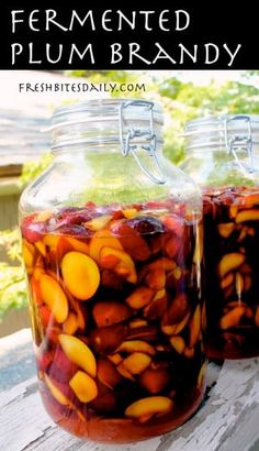 two jars filled with fruit sitting on top of a wooden table