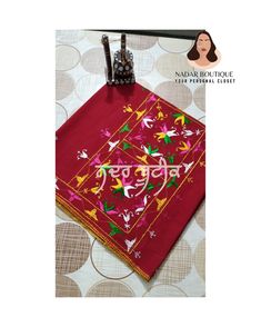 a red table cloth with birds and flowers on it