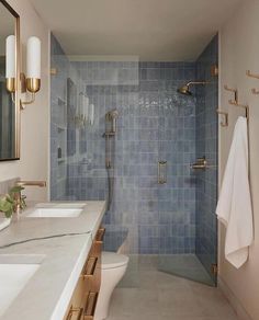 a bathroom with blue tile and gold fixtures