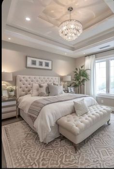 a bedroom with a large bed and chandelier in it's centerpiece