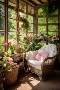 a room with lots of plants and flowers in the window sill, along with a wicker chair that has pink pillows on it