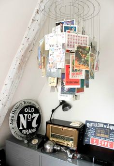 an old radio sits on top of a dresser in a room with posters hanging from the ceiling