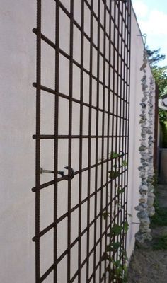 a white wall with a metal grid on it