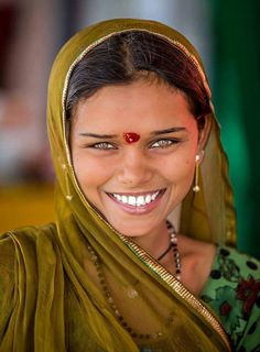 a woman wearing a headscarf and smiling for the camera