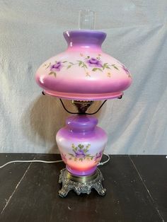 a purple lamp sitting on top of a wooden table