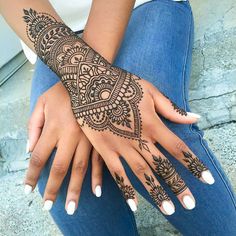 a woman's hand with henna tattoos on it