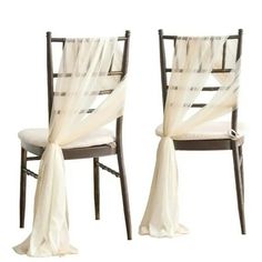 two chairs with white drapes on them