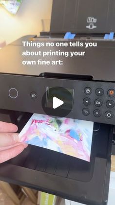 a person holding up a printer with an ad on the screen that says things no one tells you about printing your own fine art