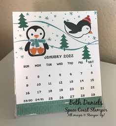 a calendar with a penguin and snowflakes on it, sitting on top of a table