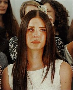 a woman with long brown hair sitting next to other people