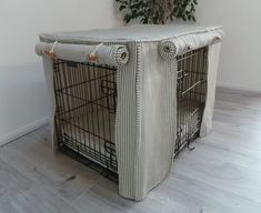 a dog crate with a cover on it's side and a plant in the background