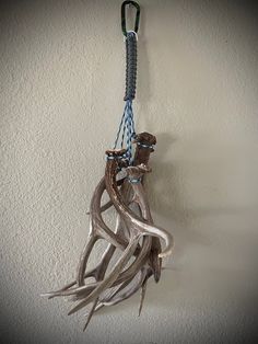 an animal hanging from a hook on a wall with ropes attached to it's sides