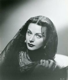 an old black and white photo of a woman with her head covered by a veil