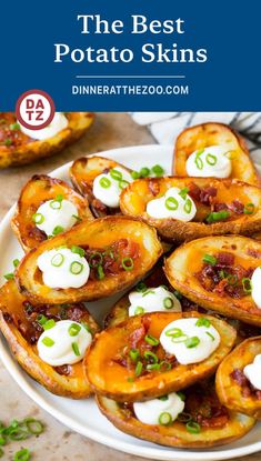 potato skins with sour cream on top and green onions in the middle, sitting on a white plate