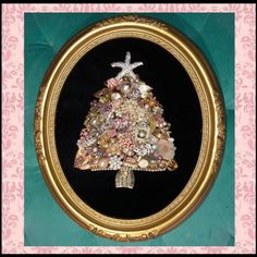 a christmas tree made out of seashells in a gold frame